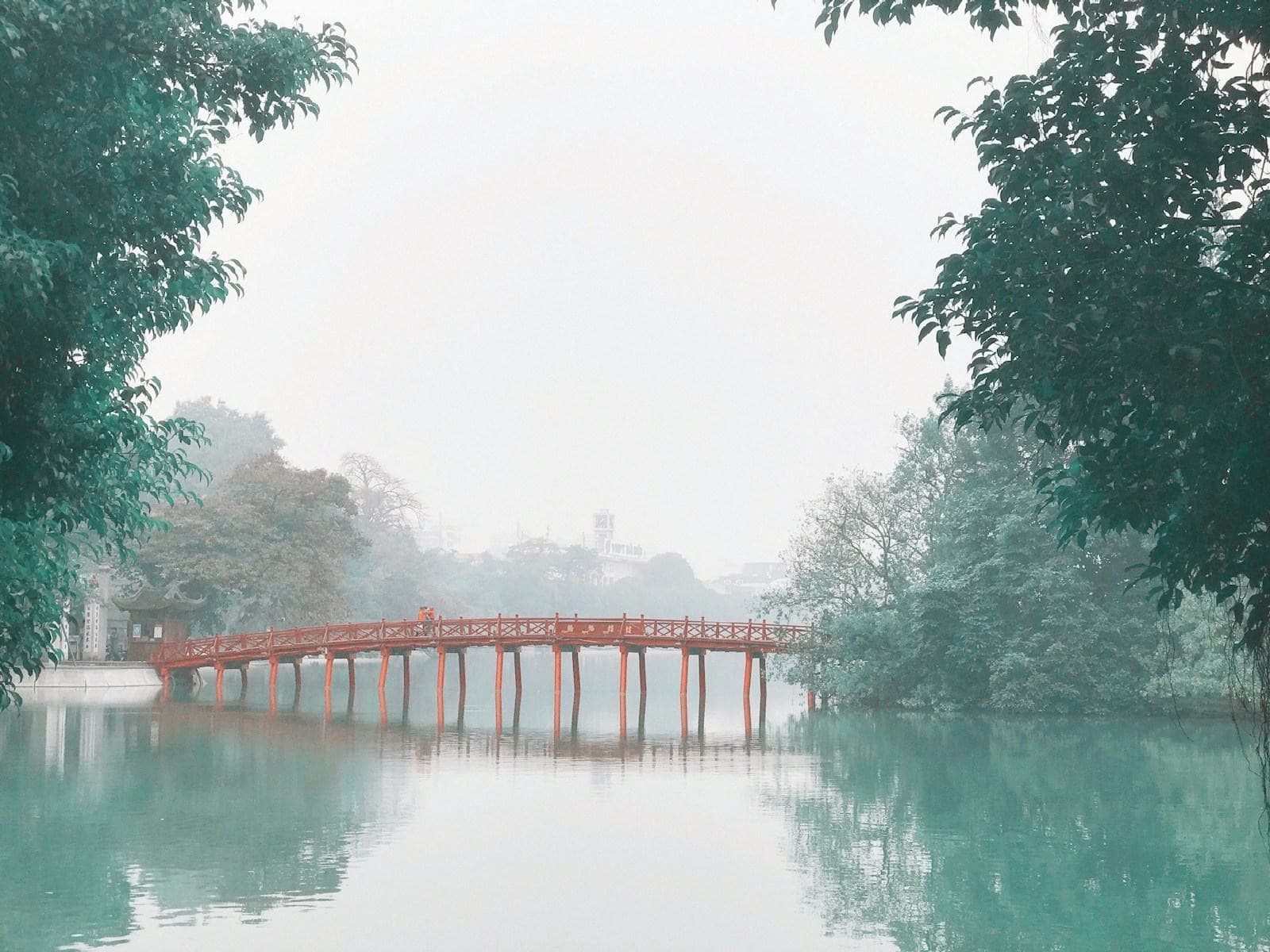 Rote Holzbrücke im Morgendunst in Hanoi