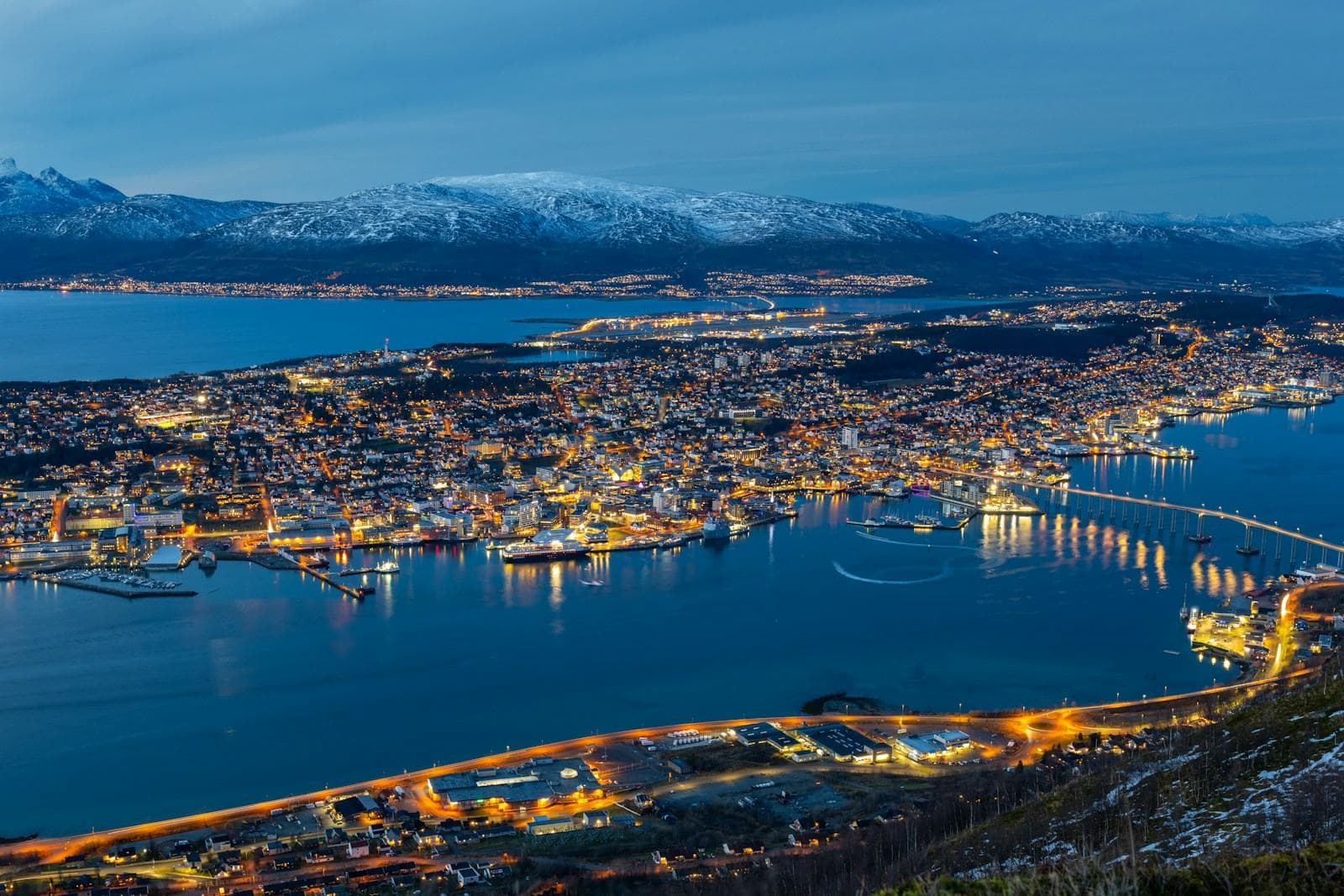 Tromsø in der blauen Stunde mit Brücke und verschneiten Bergen