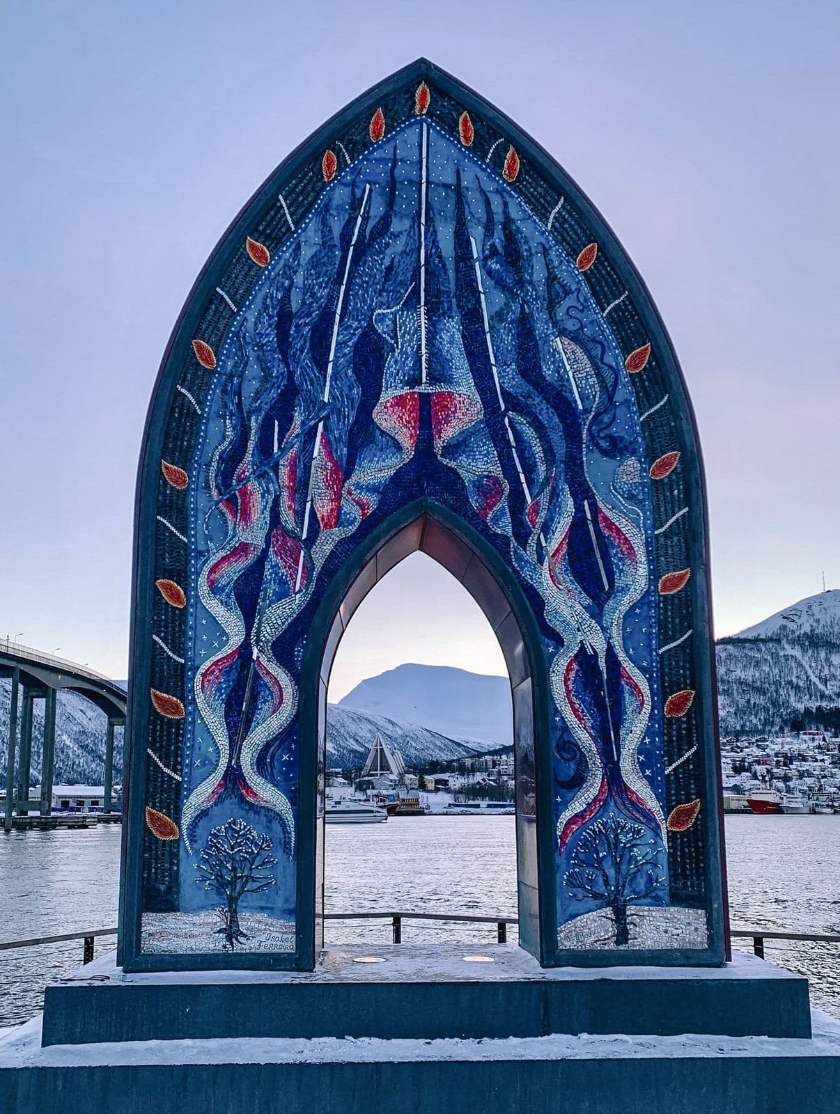 Mosaik-Torbogen am Ufer von Tromsø vor verschneiten Bergen